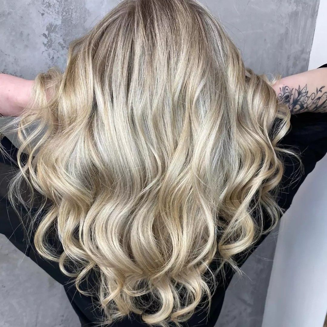 Bujne blond włosy ułożone w sprężyste loki